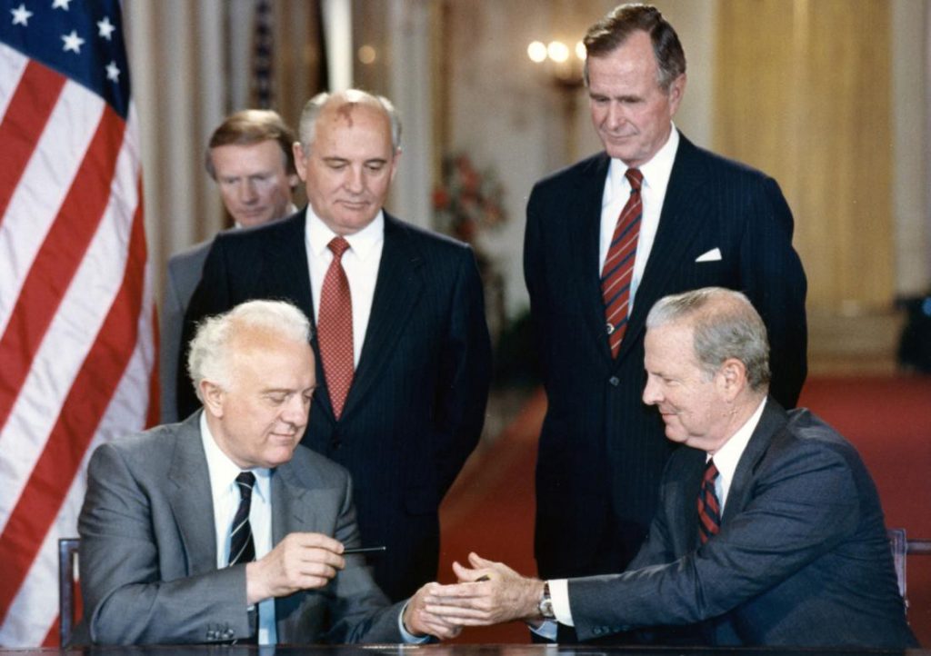 Uno scambio di penne alla firma di un trattato della Casa Bianca nel 1990 tra il ministro degli Esteri sovietico Eduard Shevardnadze (in basso a sinistra) e il Segretario di Stato americano James Baker, III (in basso a destra) sotto la supervisione dei presidenti Mikhail Gorbachev e George H.W. Bush.